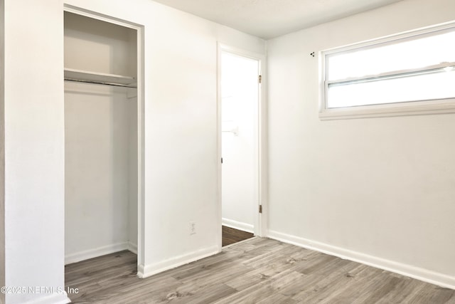 395 Arora Blvd, Orange Park, FL 32073 - unfurnished bedroom with wood finished floors, a closet, and baseboards
