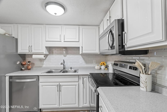 8880 Old Kings Rd S Unit 21, Jacksonville, FL 32257 - kitchen featuring a sink, white cabinetry, stainless steel appliances, light countertops, and decorative backsplash