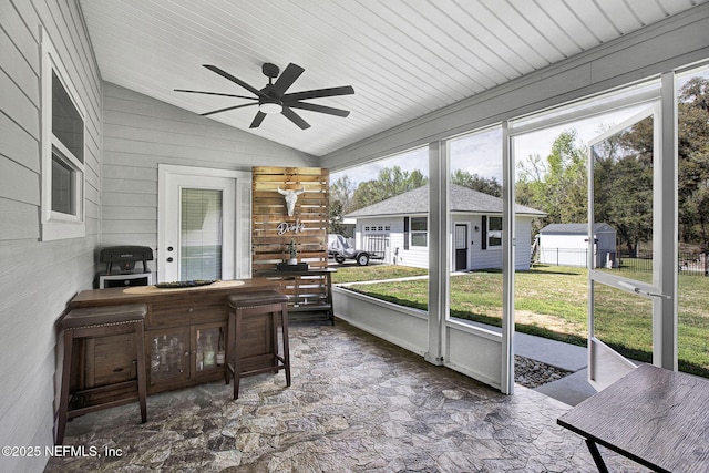 sunroom / solarium featuring lofted ceiling and a ceiling fan