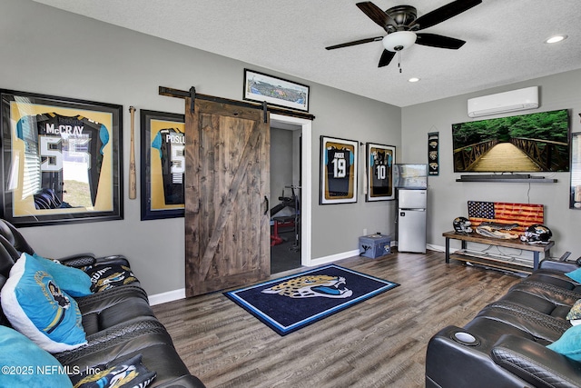 living room with baseboards, wood finished floors, a ceiling fan, and a wall unit AC