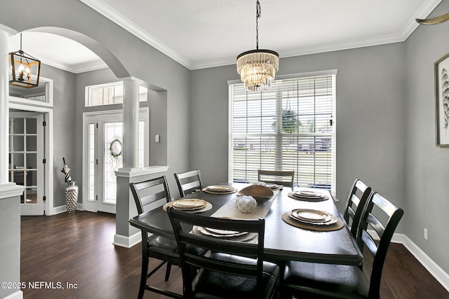 dining room featuring baseboards, arched walkways, ornamental molding, dark wood-type flooring, and a notable chandelier