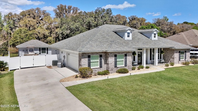 view of front of property featuring a shingled roof, a front yard, central AC, driveway, and a gate