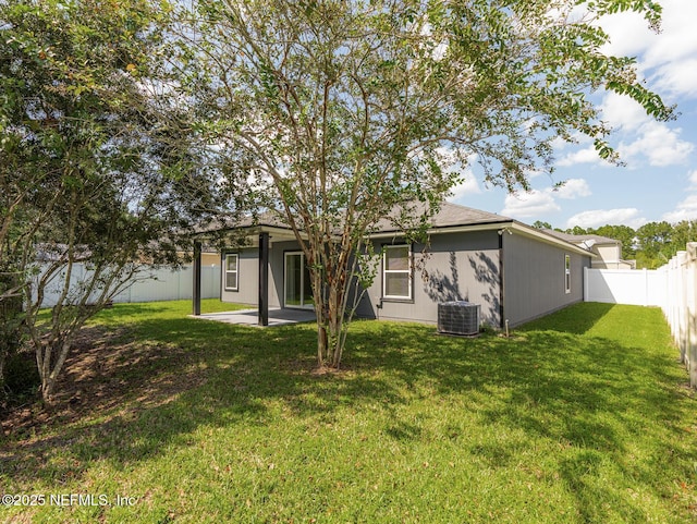 back of house featuring central AC unit, a patio, a yard, and a fenced backyard