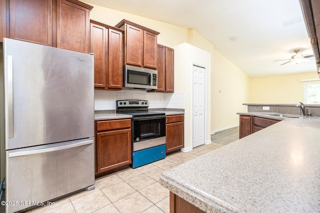 kitchen with a sink, appliances with stainless steel finishes, light tile patterned flooring, decorative backsplash, and ceiling fan