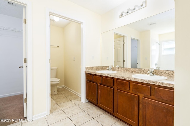 bathroom featuring a sink, visible vents, toilet, and tile patterned floors