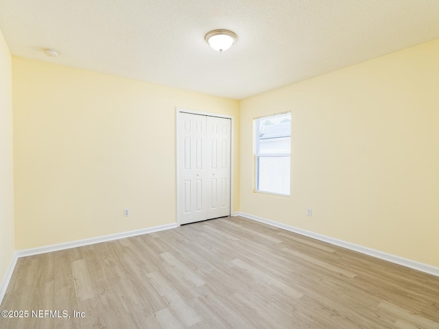 empty room with baseboards and light wood-style floors