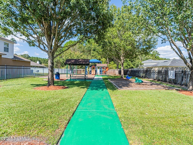 view of home's community featuring fence, a lawn, and playground community