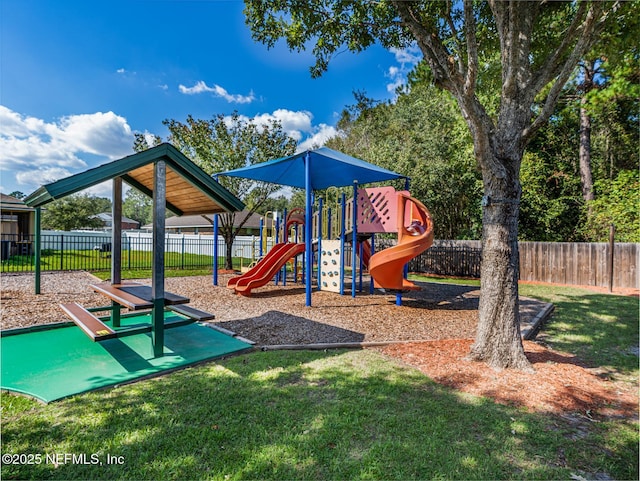 community playground featuring fence and a lawn