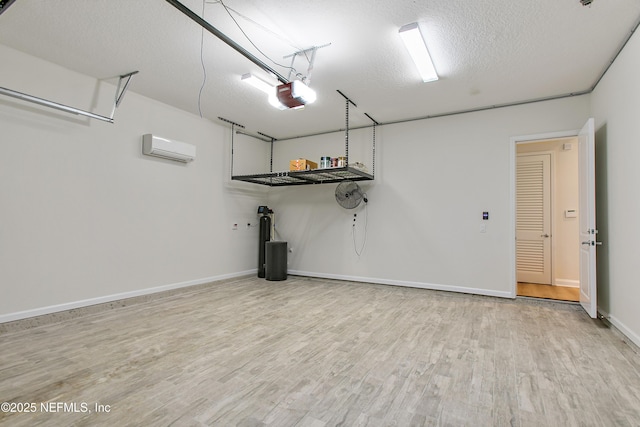 garage featuring an AC wall unit, a garage door opener, and baseboards