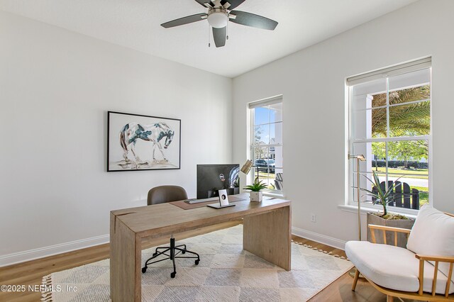 office area with light wood-style flooring, baseboards, and ceiling fan