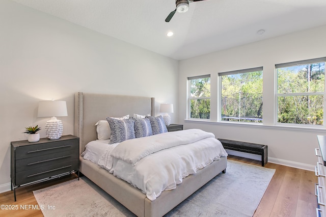 bedroom with vaulted ceiling, recessed lighting, wood finished floors, and baseboards