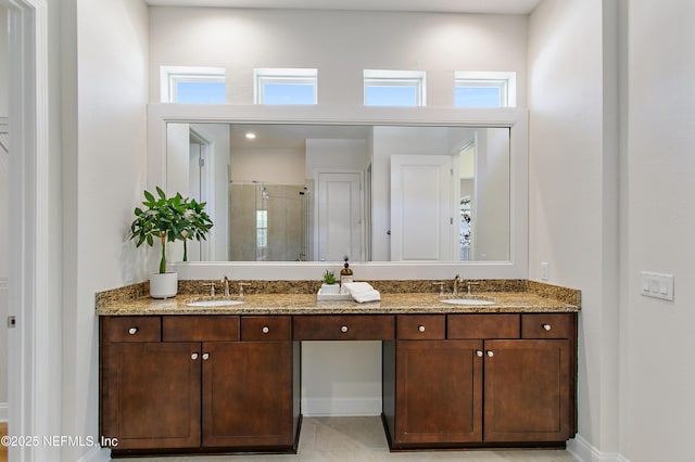 bathroom with double vanity, a stall shower, and a sink