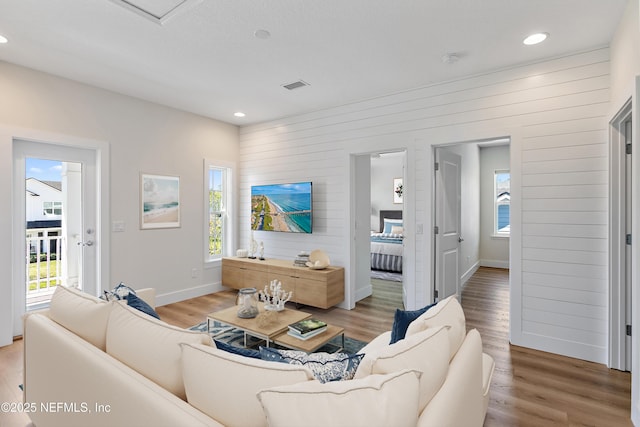 living area with light wood-style flooring, recessed lighting, baseboards, and visible vents