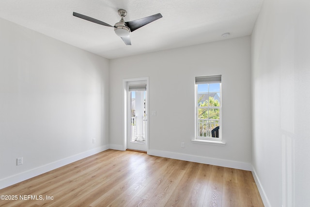 unfurnished room with a ceiling fan, light wood-type flooring, and baseboards