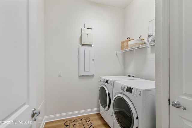 laundry area with laundry area, baseboards, light wood-style floors, and separate washer and dryer