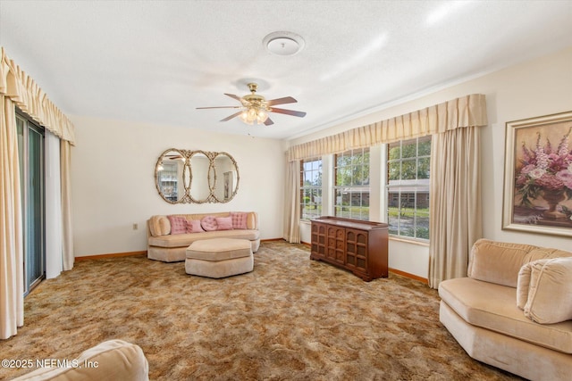 carpeted living room featuring a textured ceiling, baseboards, and ceiling fan