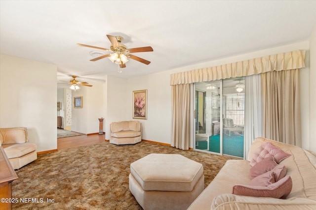 living room featuring baseboards, carpet, and a ceiling fan