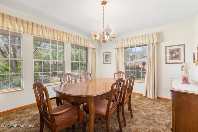 dining space featuring light carpet, a notable chandelier, and baseboards