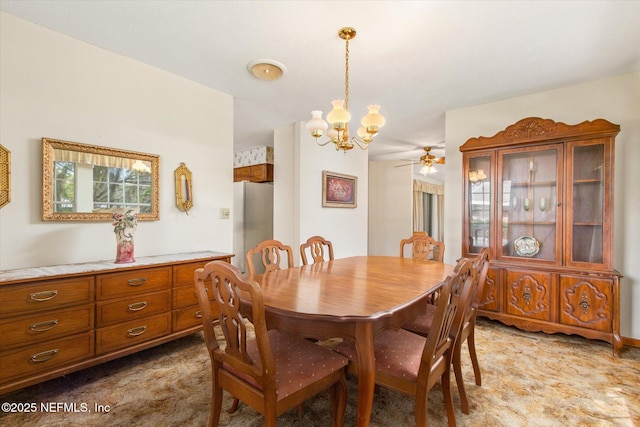 dining room with light colored carpet and ceiling fan with notable chandelier