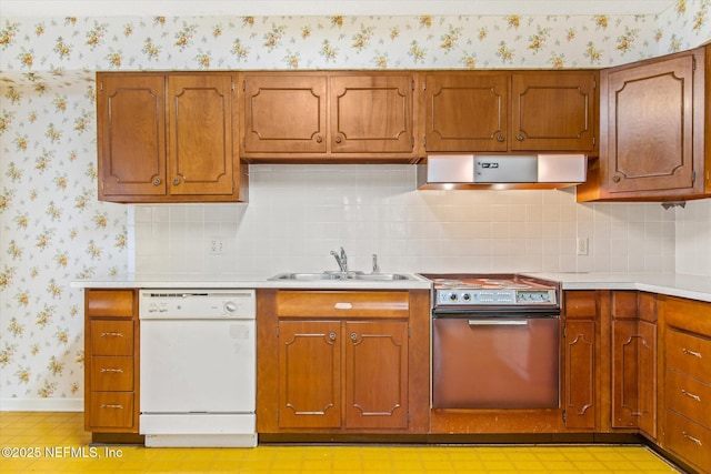 kitchen featuring a sink, electric range oven, ventilation hood, white dishwasher, and wallpapered walls