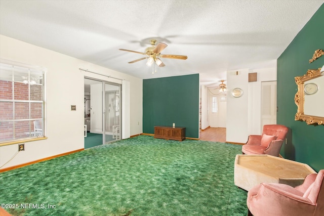 living area with baseboards, a textured ceiling, carpet, and a ceiling fan