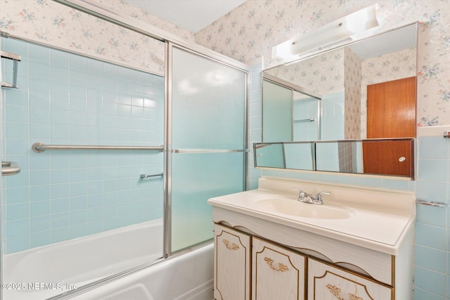 full bath with wallpapered walls, vanity, wainscoting, and enclosed tub / shower combo