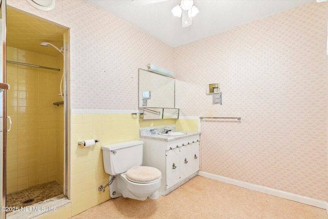 full bath with wainscoting, a stall shower, wallpapered walls, and toilet