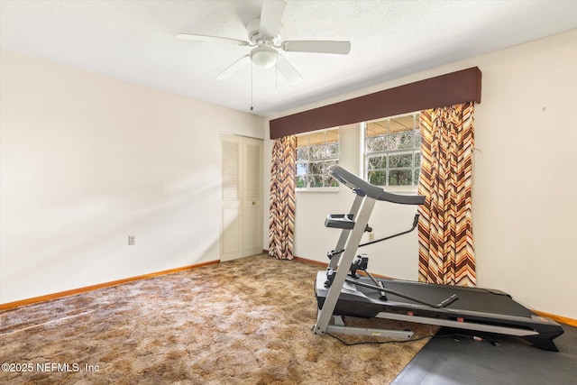 exercise room with a ceiling fan, baseboards, carpet floors, and a textured ceiling