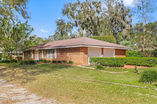 view of front of home with a front yard, brick siding, and a garage