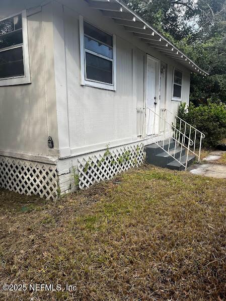 property entrance featuring a lawn