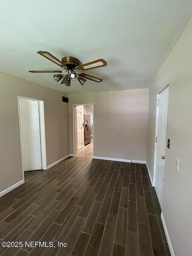 unfurnished room with visible vents, baseboards, ceiling fan, and wood tiled floor