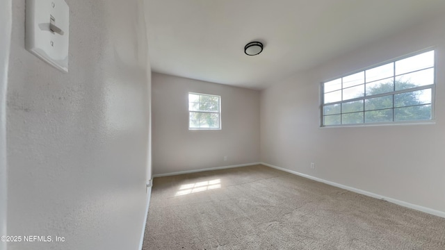 spare room with baseboards and carpet flooring