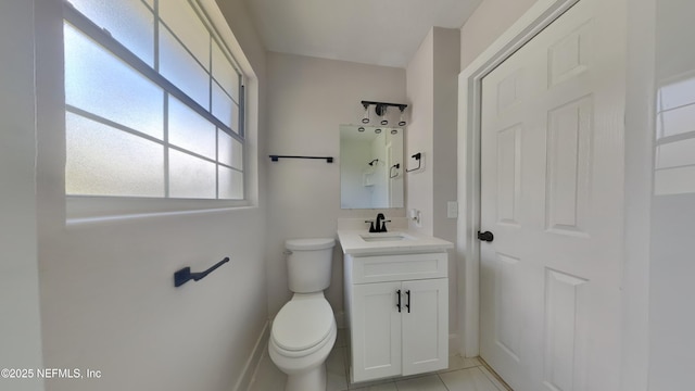 bathroom featuring vanity, tile patterned floors, toilet, and baseboards