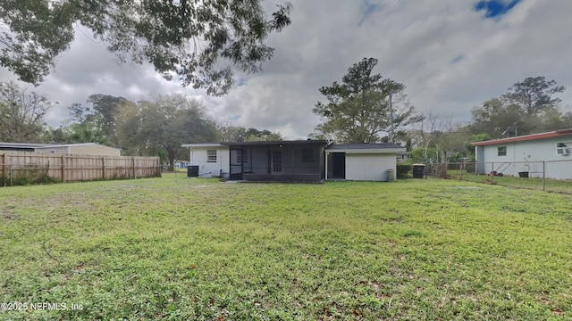 rear view of house with a lawn and a fenced backyard