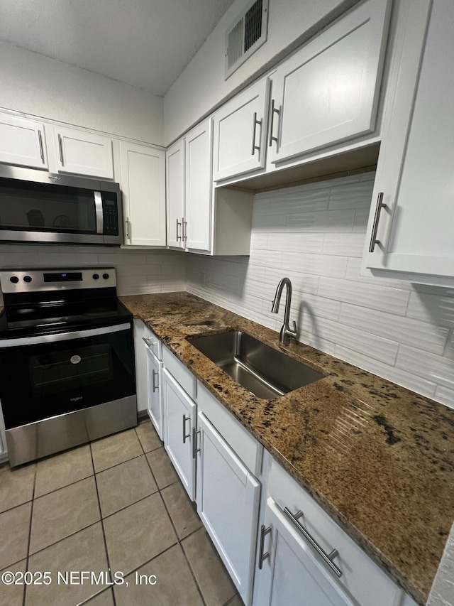 kitchen featuring tasteful backsplash, visible vents, stainless steel appliances, and a sink