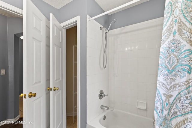 full bath with a textured ceiling and shower / tub combo