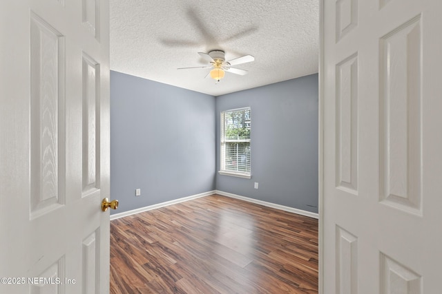 unfurnished room featuring baseboards, wood finished floors, a textured ceiling, and ceiling fan