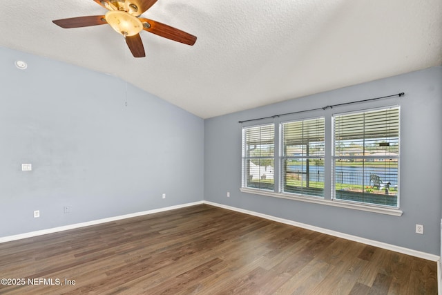 spare room with a ceiling fan, baseboards, dark wood finished floors, lofted ceiling, and a textured ceiling