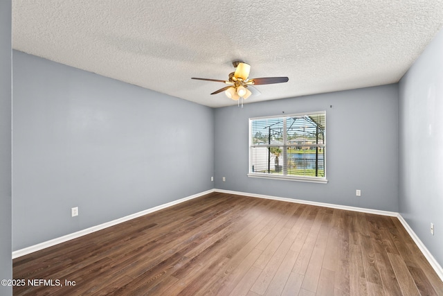 unfurnished room with a textured ceiling, baseboards, ceiling fan, and dark wood-style flooring