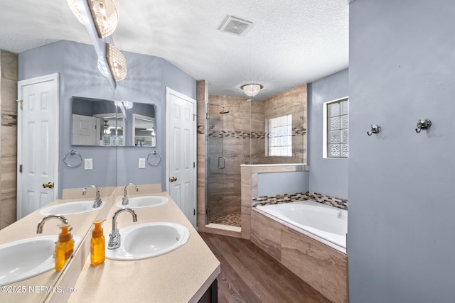 full bath with visible vents, a textured ceiling, and a sink