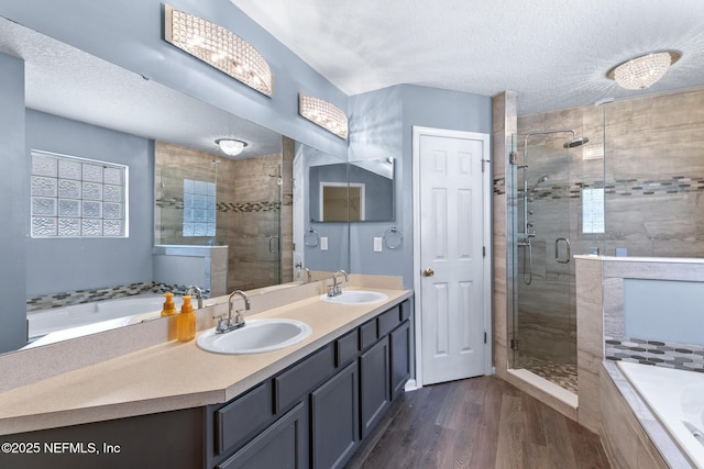 bathroom featuring a sink, a garden tub, a stall shower, and wood finished floors