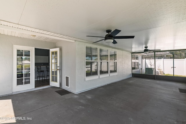 unfurnished sunroom featuring a ceiling fan