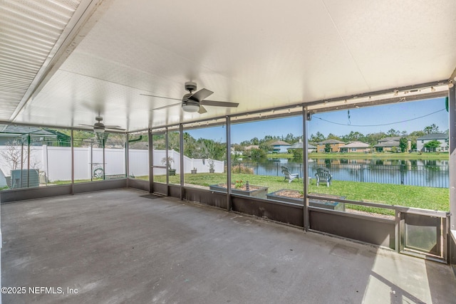 unfurnished sunroom with a water view and ceiling fan