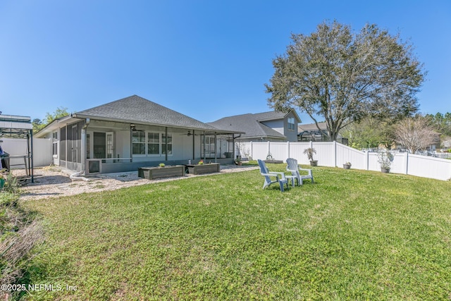 back of property featuring a ceiling fan, a yard, a fenced backyard, and a sunroom