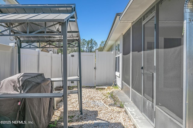 exterior space featuring a gate, fence, and a sunroom