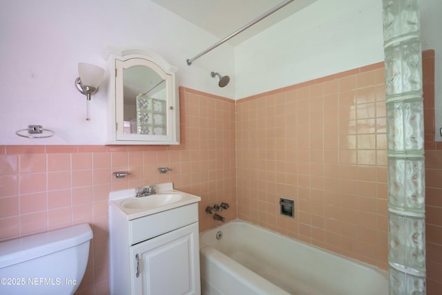 full bathroom featuring vanity, shower / bathtub combination with curtain, wainscoting, tile walls, and toilet