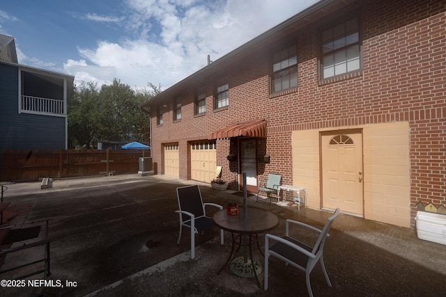 view of patio / terrace featuring a garage and fence