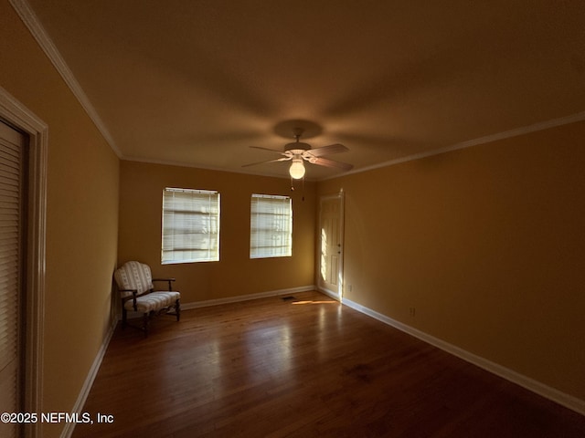 unfurnished room with baseboards, a ceiling fan, wood finished floors, and crown molding