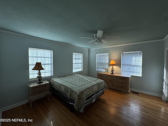 bedroom featuring visible vents, wood finished floors, baseboards, and ornamental molding