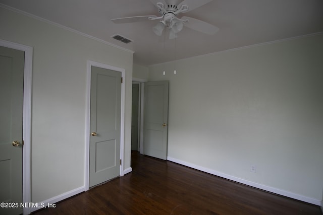 unfurnished bedroom with crown molding, wood finished floors, visible vents, and baseboards